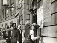 97400 Afbeelding van het aanplakken van de oproep tot algehele mobilisatie op de gevel van het Stadhuis (Stadhuisbrug ...